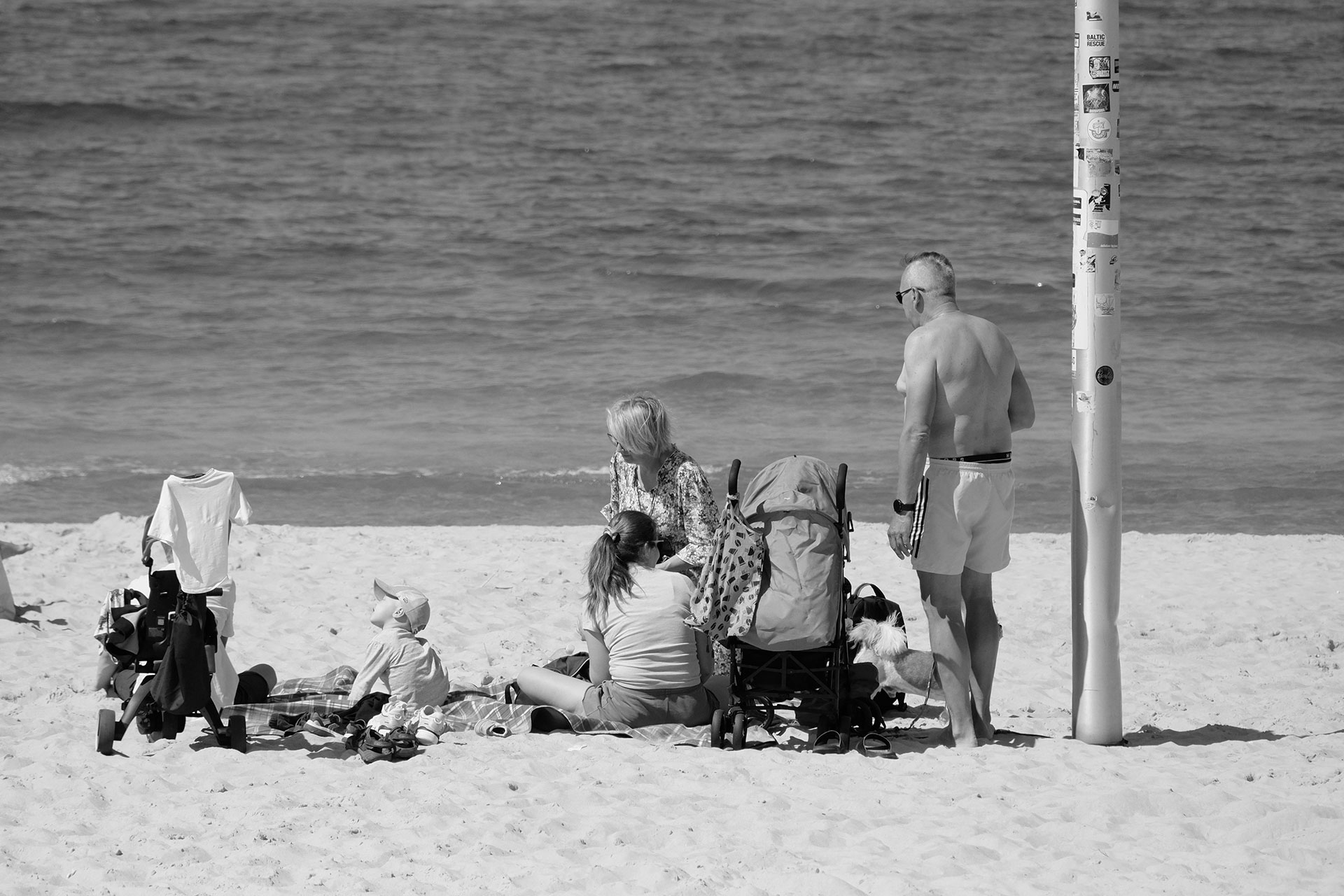 Een zwart-wit foto van een familie op het strand.